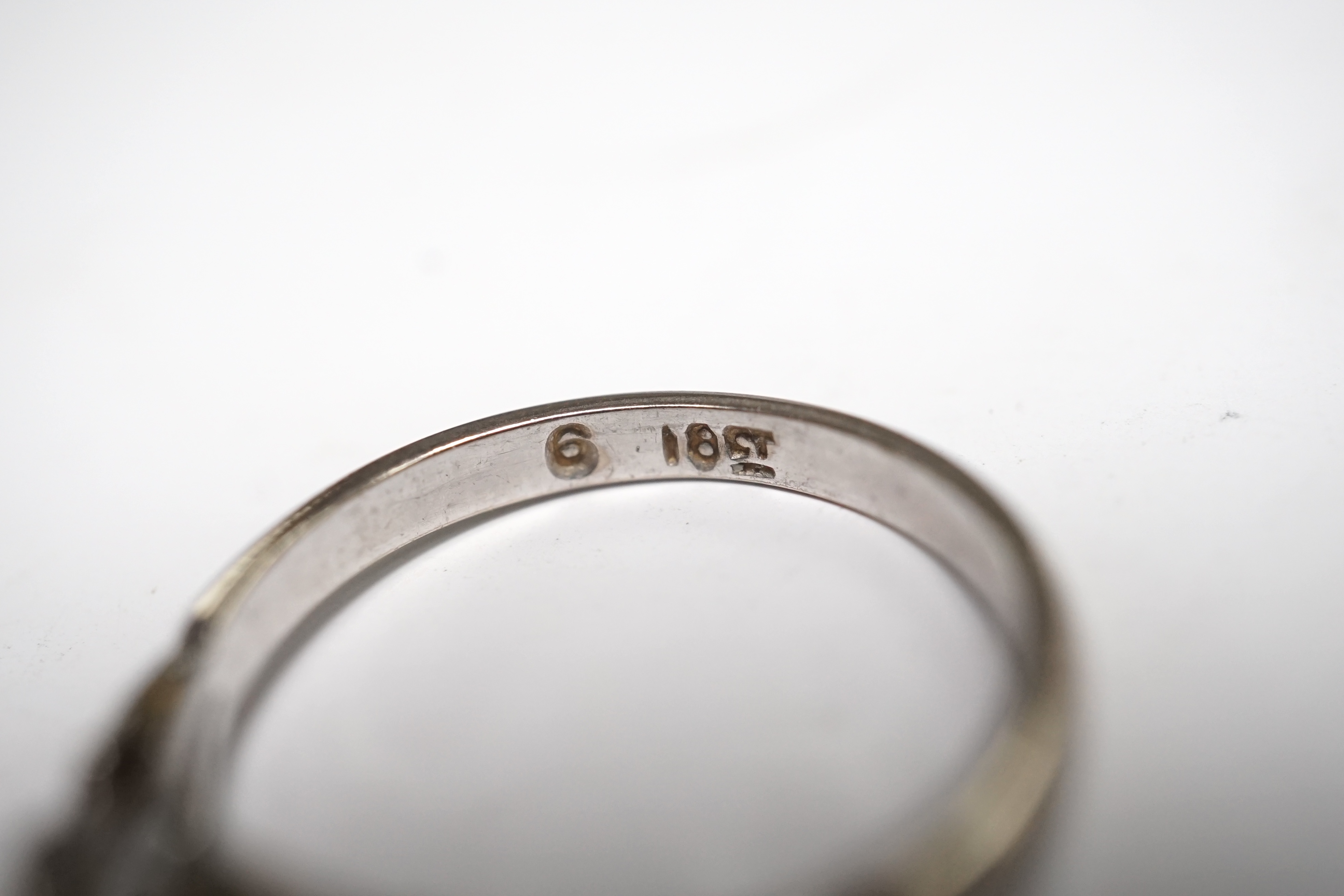 An 18ct white metal and cushion cut solitaire diamond ring, size N/O, gross weight 2.6 grams. Condition - fair